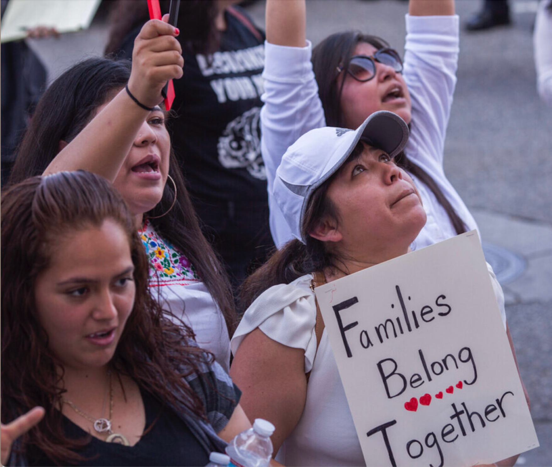 Community members at an immigration-related demonstration holding a Families Belong Together sign